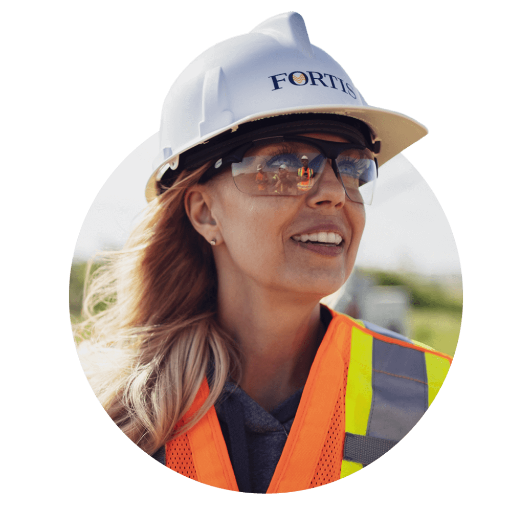 Customer-Focused 3 Woman with safety glasses, vest, and a Fortis hard hat